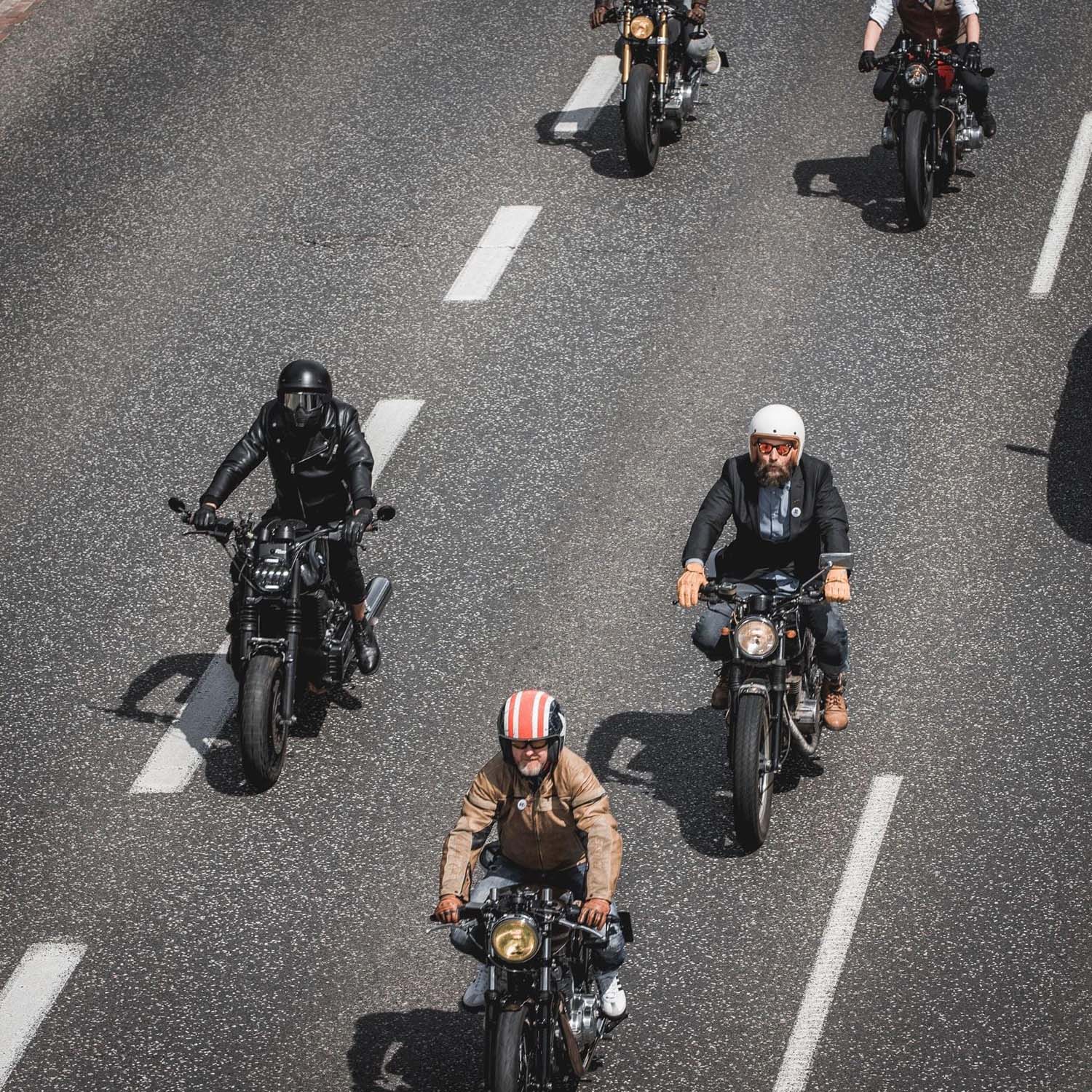 Three riders on custom motorcycles photographed from above on an empty Warsaw road
